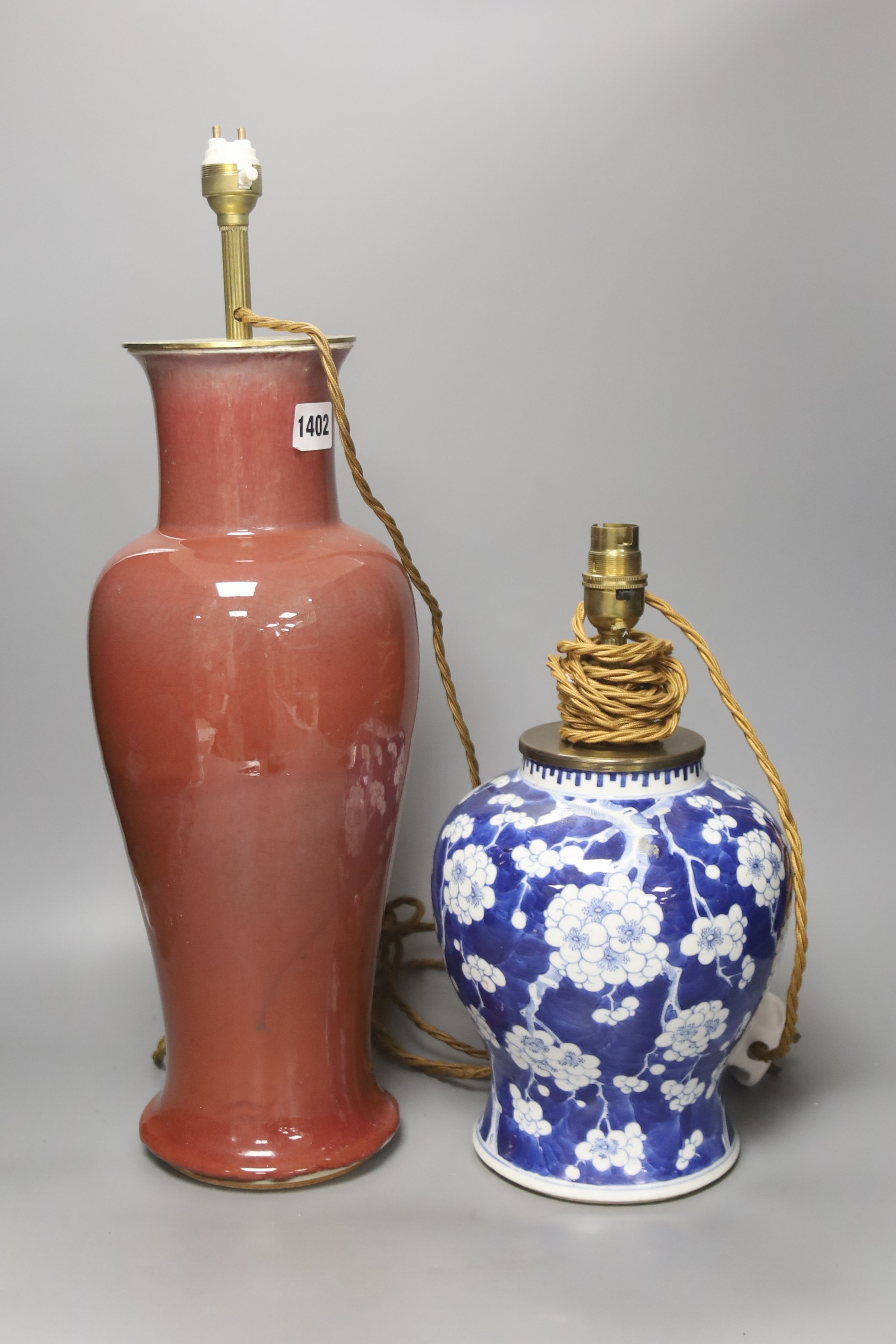 A large Chinese sang de boeuf lamp base and a similar blue and white prunus lamp base, both Qing dynasty, 41 and 21 cm high excluding fittings